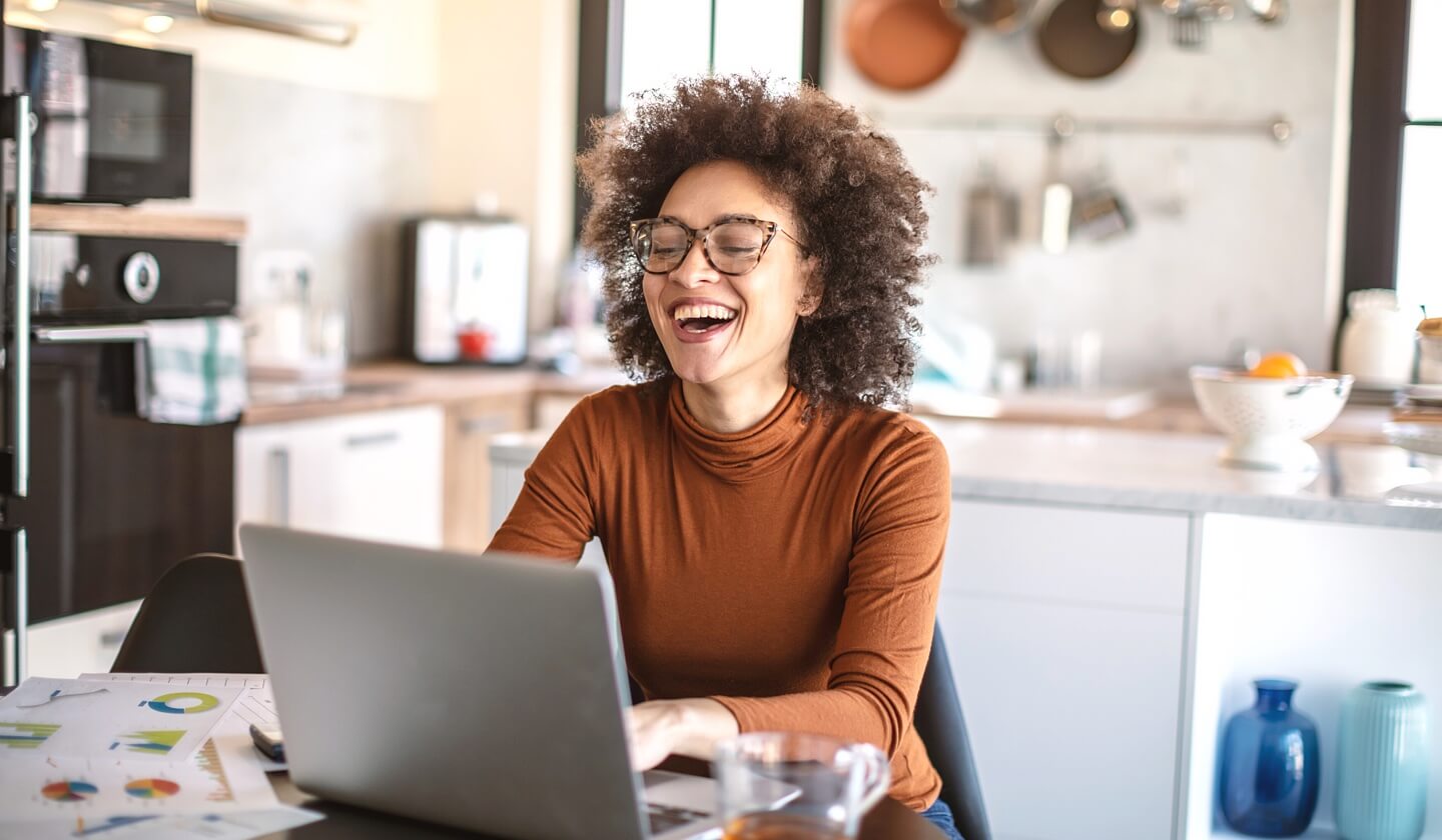 Fintech woman leader receiving email to laptop in kitchen