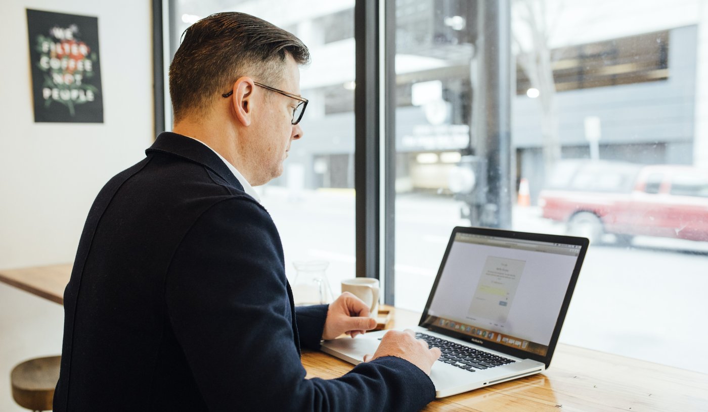 Man using his laptop in cafe as part of remote working following the global pandemic