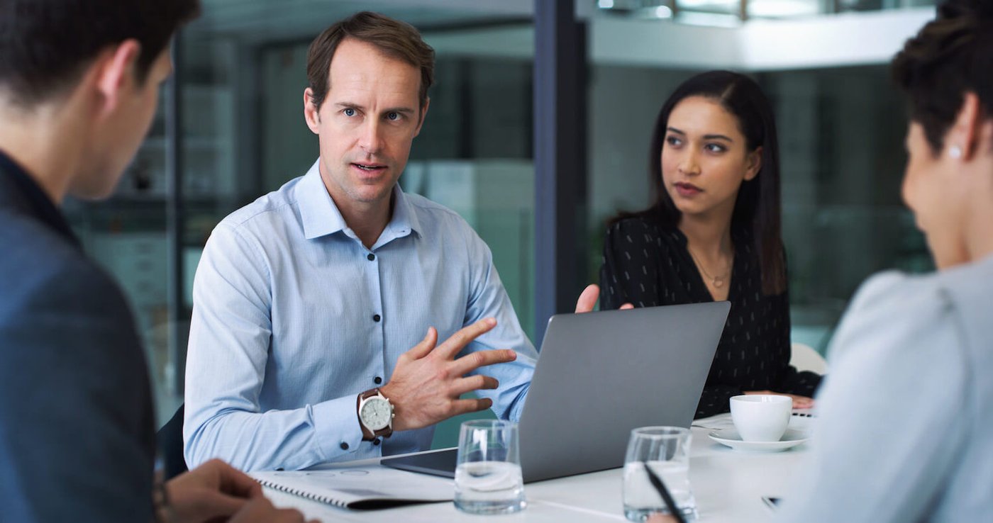 man explaining how email encryption works to colleagues in board room