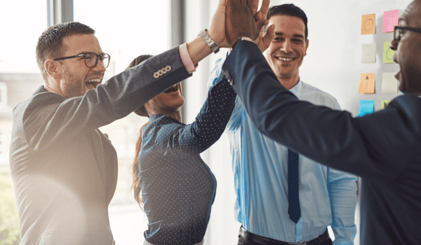 colleagues high-five over successful business venture