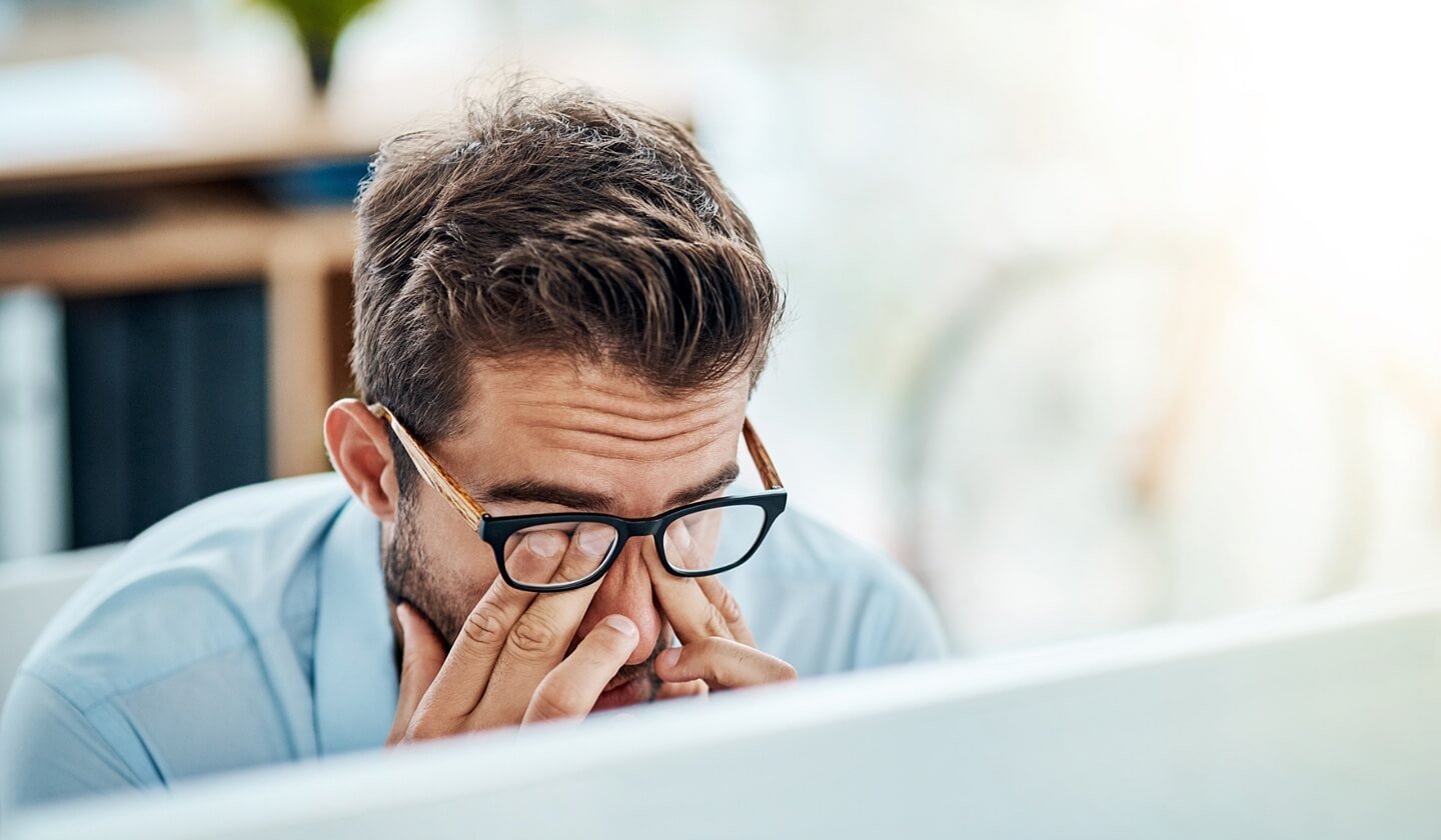 Business professional stressed in office working at computer