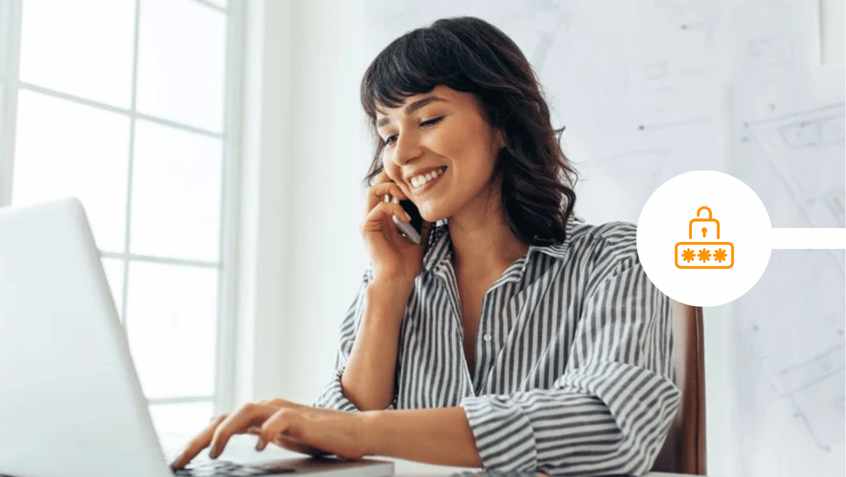 Woman in an office on the phone and using her laptop