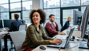 woman smiling at desktop computer and using secure email solution